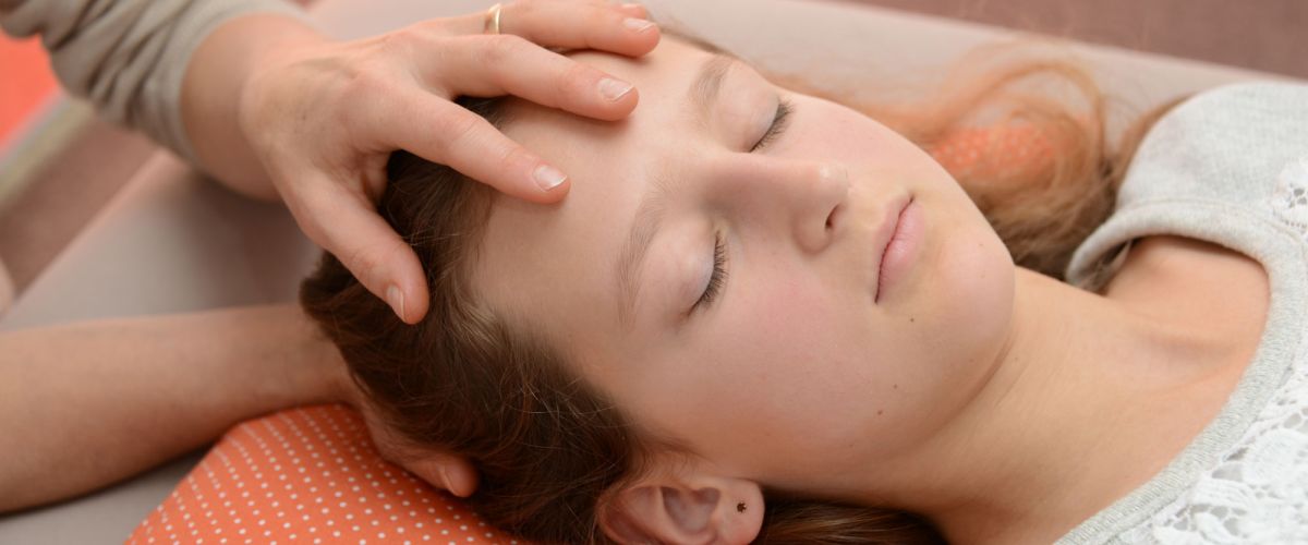 Kind liegend während Behandlung am Kopf